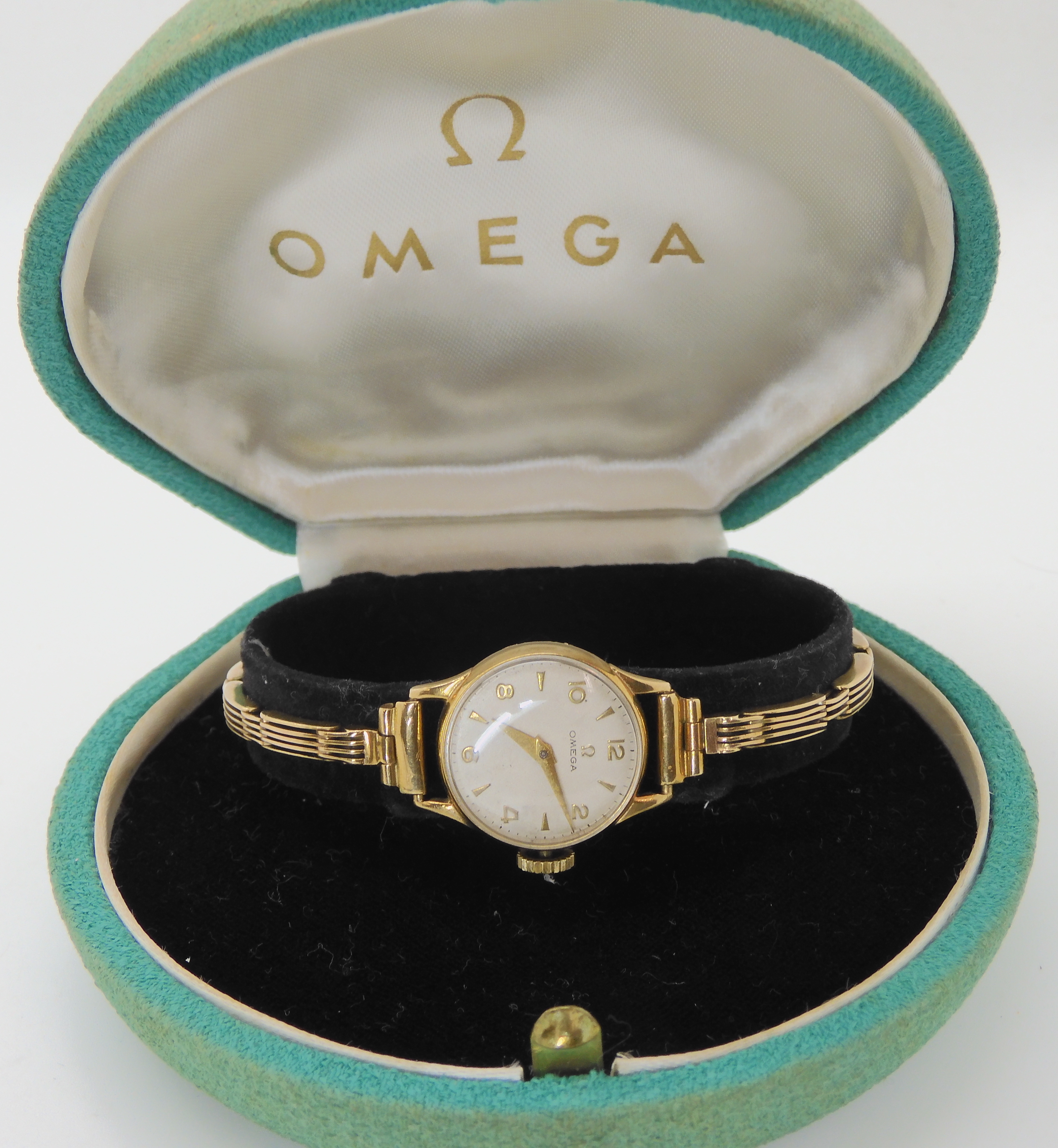 A 9CT GOLD LADIES VINTAGE OMEGA WRISTWATCH with a cream dial with gold coloured Arabic and chevron