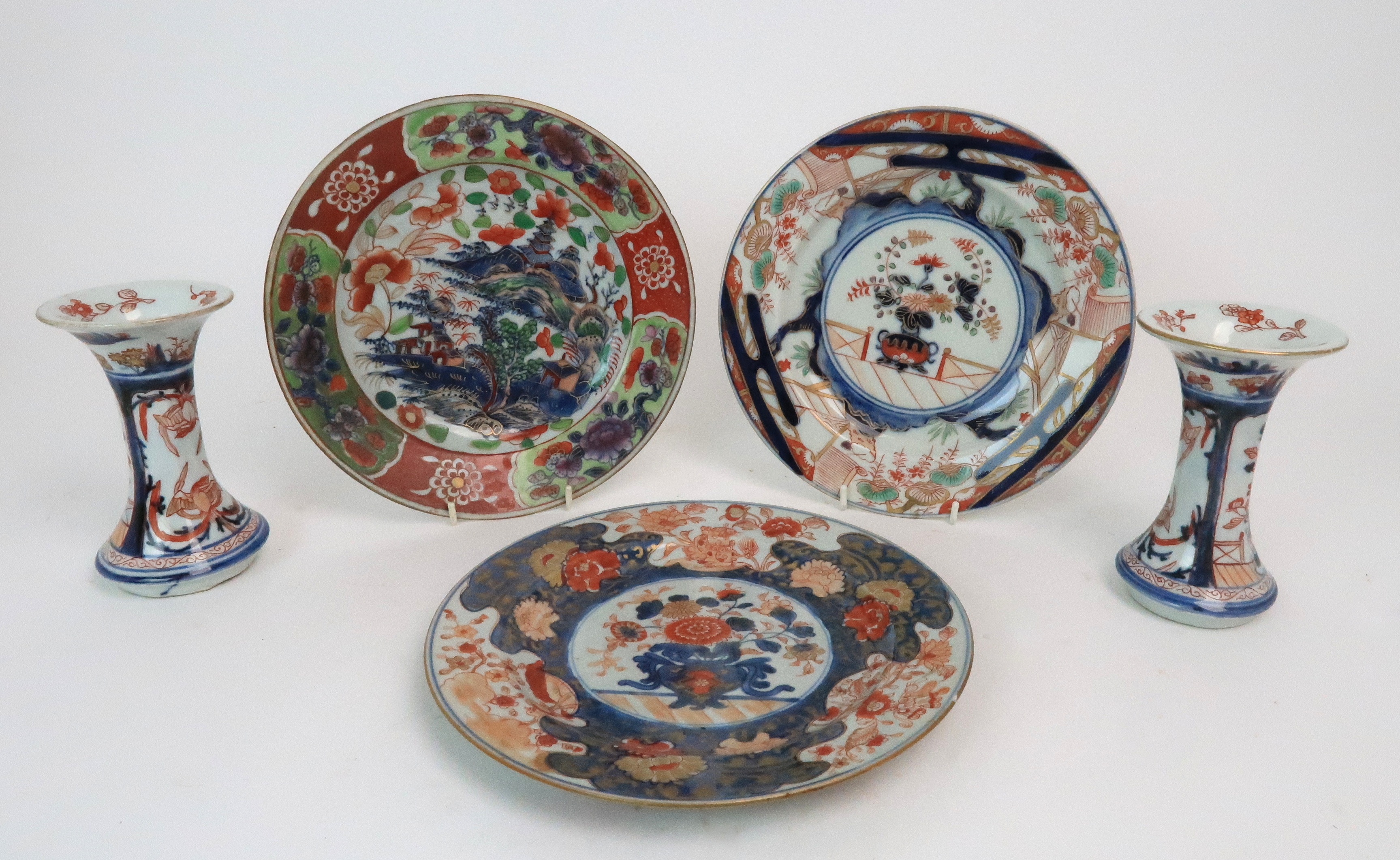 THREE CHINESE EXPORT IMARI PATTERN PLATES painted with vases of flowers and a landscape, 23 and 23.