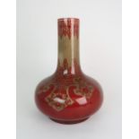 A BERNARD MOORE POTTERY VASE of bottle form, decorated in red with scrolling foliate design, marks