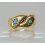 AN 18CT GOLD DOUBLE SNAKE RING set with turquoise to the head and diamond eyes. Birmingham hallmarks