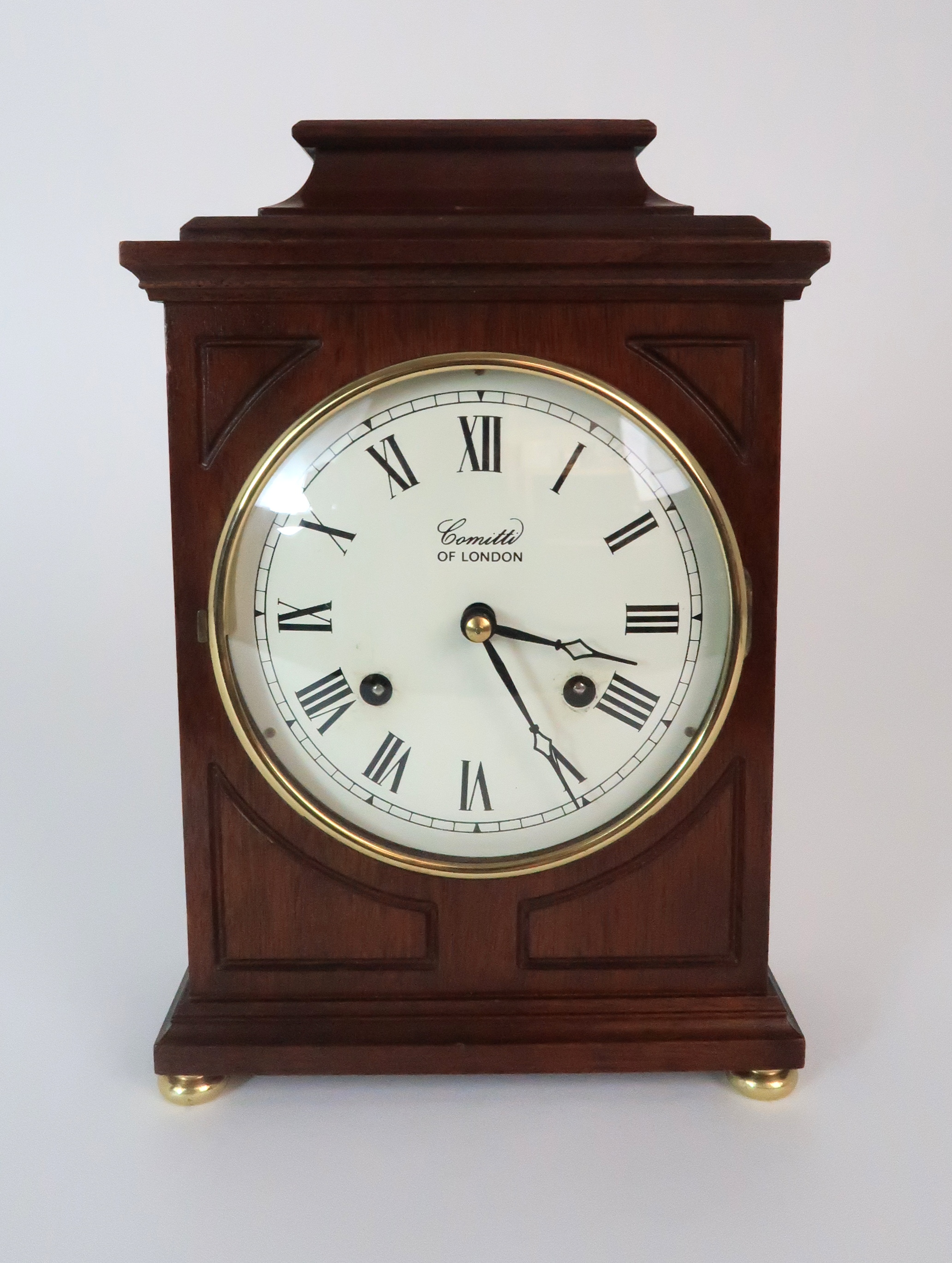 A COMITTI OF LONDON MANTLE CLOCK the wooden case with white dial and Roman numerals, the brass