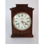 A COMITTI OF LONDON MANTLE CLOCK the wooden case with white dial and Roman numerals, the brass