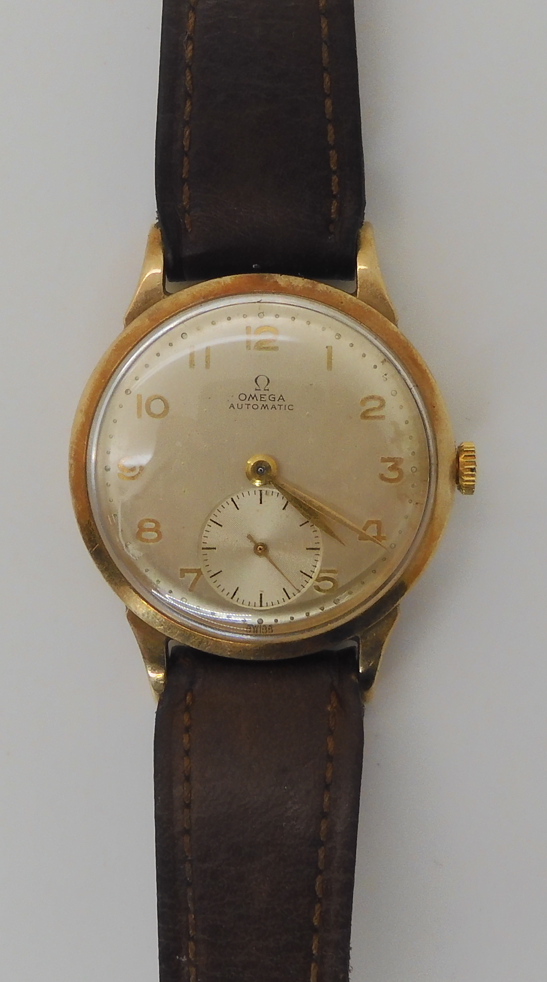 A 9CT GOLD GENTS VINTAGE OMEGA AUTOMATIC with silvered dial, gold coloured numbers and hands and a