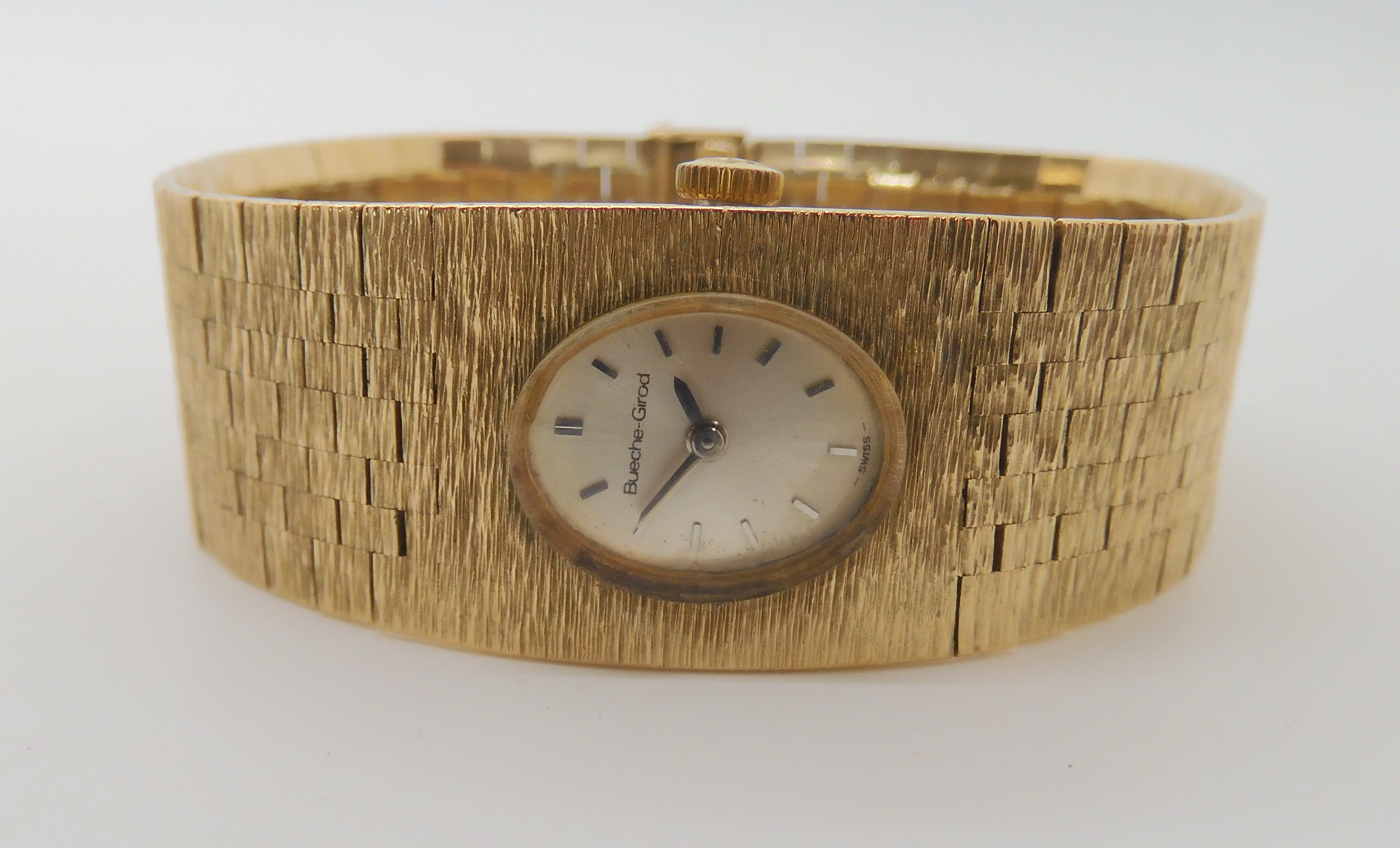 A 9CT GOLD RETRO BUECHE GIROD LADIES WATCH with integral bark textured strap, length 16cm width at