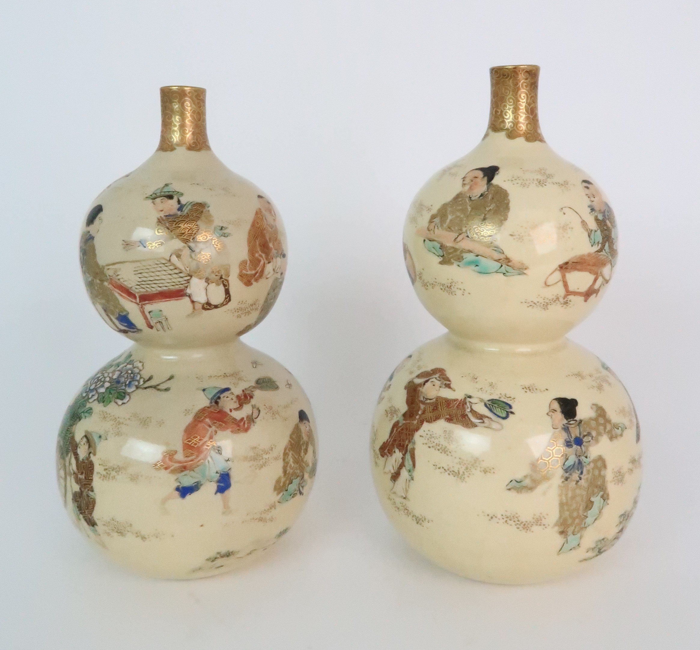 A PAIR OF SATSUMA DOUBLE GOURD VASES each painted with figures playing in gardens, with red and gilt