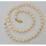 A STRING OF BAROQUE PEARLS with a 9ct gold clasp, each pearl approx 6.5mm, length 37cm, weight 21.
