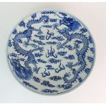 A CHINESE BLUE AND WHITE CIRCULAR DISH painted with two dragons surrounding the flaming pearl,
