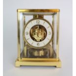 A JAEGER LE COULTRE ATMOS CLOCK in glazed brass case, the white enamel chapter ring with applied