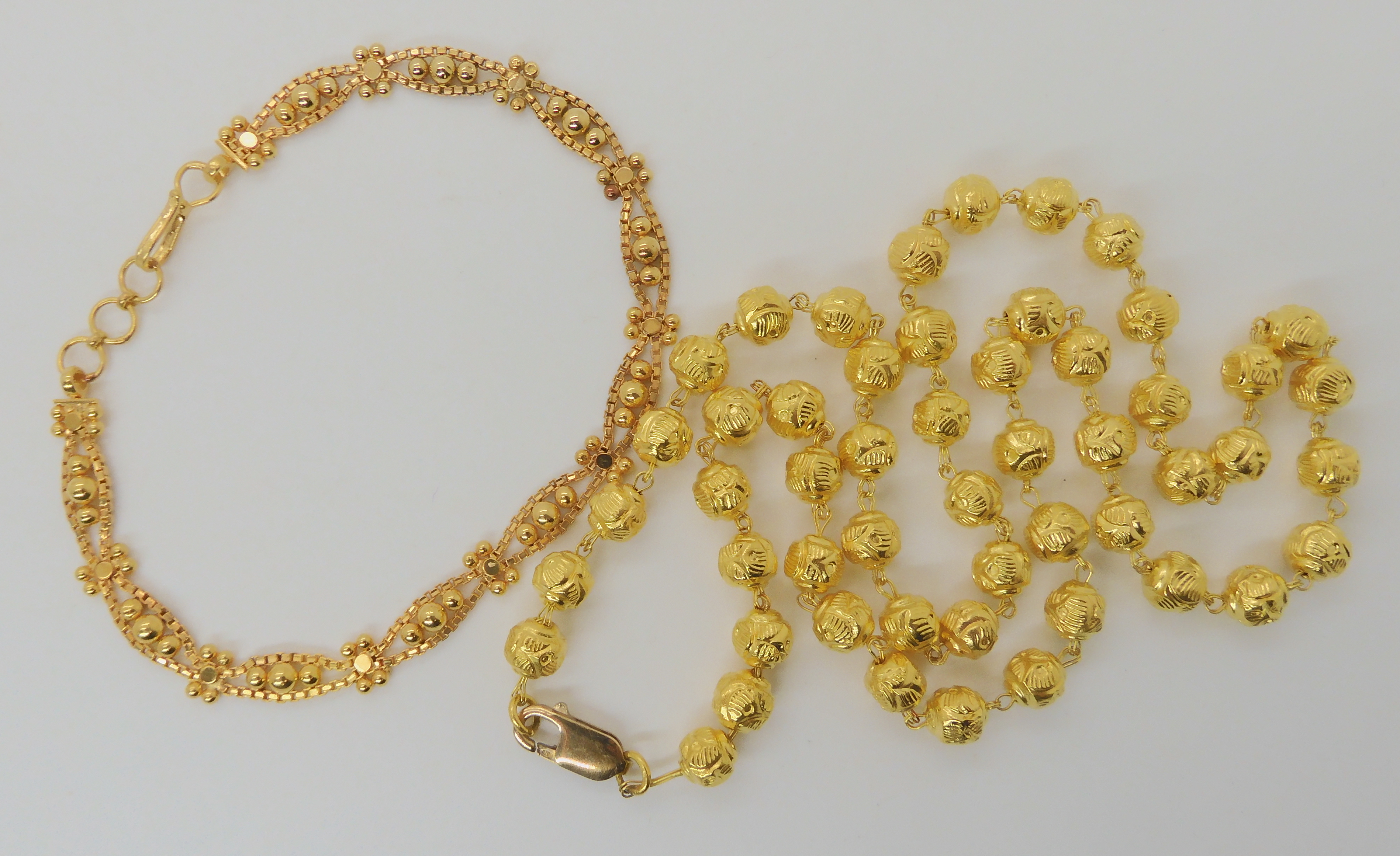 A BRIGHT YELLOW METAL BEAD NECKLACE, AND BRACELET bead necklace, is bright yellow metal with a UK,