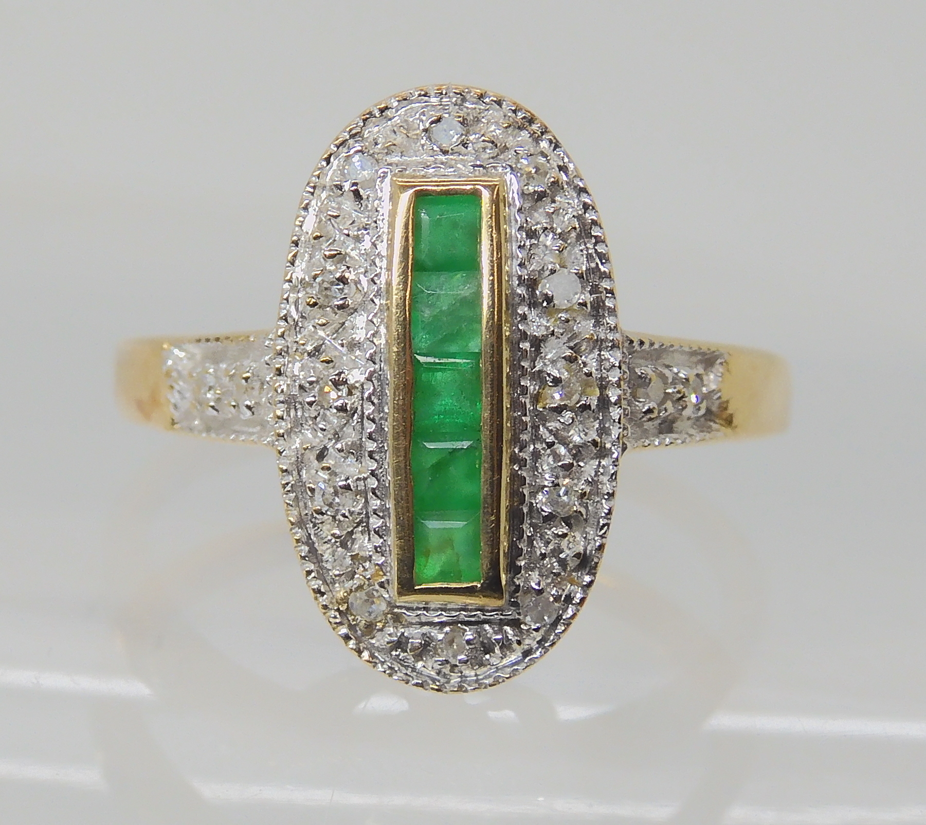 A 9CT GOLD ART DECO STYLE RING set with square cut emeralds and diamond accents, finger size O1/2,