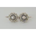 A PAIR OF DIAMOND CLUSTER EARRINGS mounted in white metal with continental hook clasps. Set with