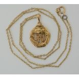 A CHINESE 16K GOLD DRAGON PENDANT the dragon coiled around a Chinese symbol, Chinese stamps to the