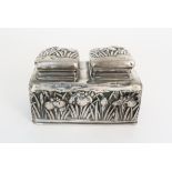 A JAPANESE WHITE METAL DOUBLE INKWELL cast with irises and set with two hinged covers above a