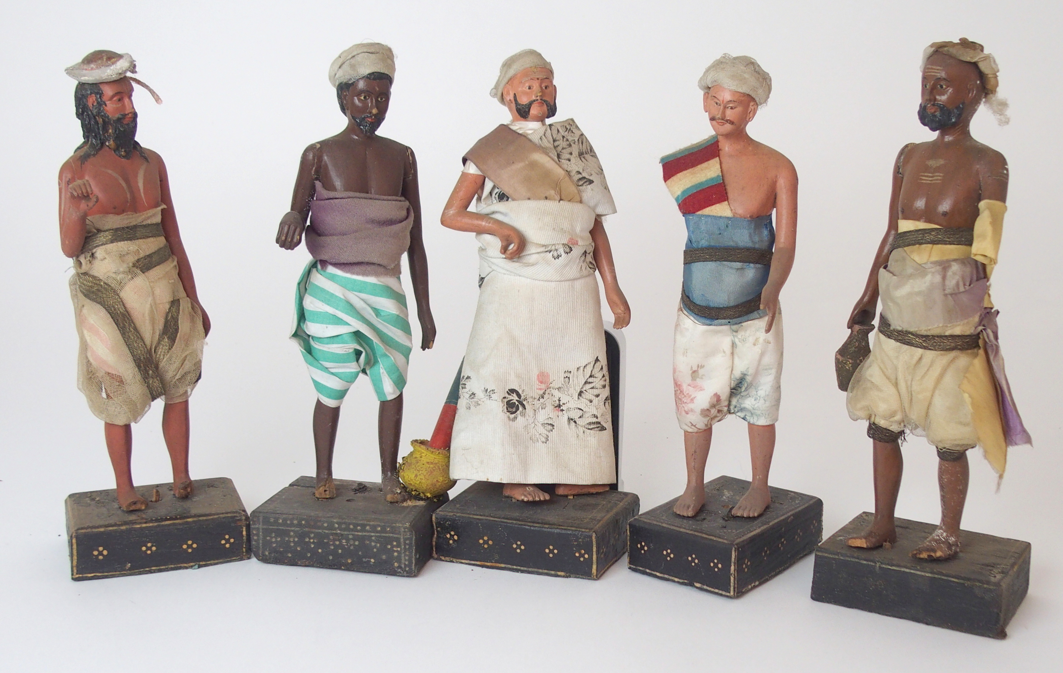 TEN INDIAN PAINTED WOOD FIGURES each native figure standing and wearing traditional dress, mounted