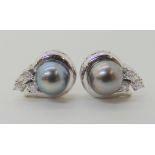 A PAIR OF BLACK PEARL AND DIAMOND EARRINGS mounted in white metal with Arabic markings, the pearls