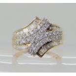 A 9CT GOLD DIAMOND CLUSTER RING set with baguette and brilliant cut diamonds to an estimated
