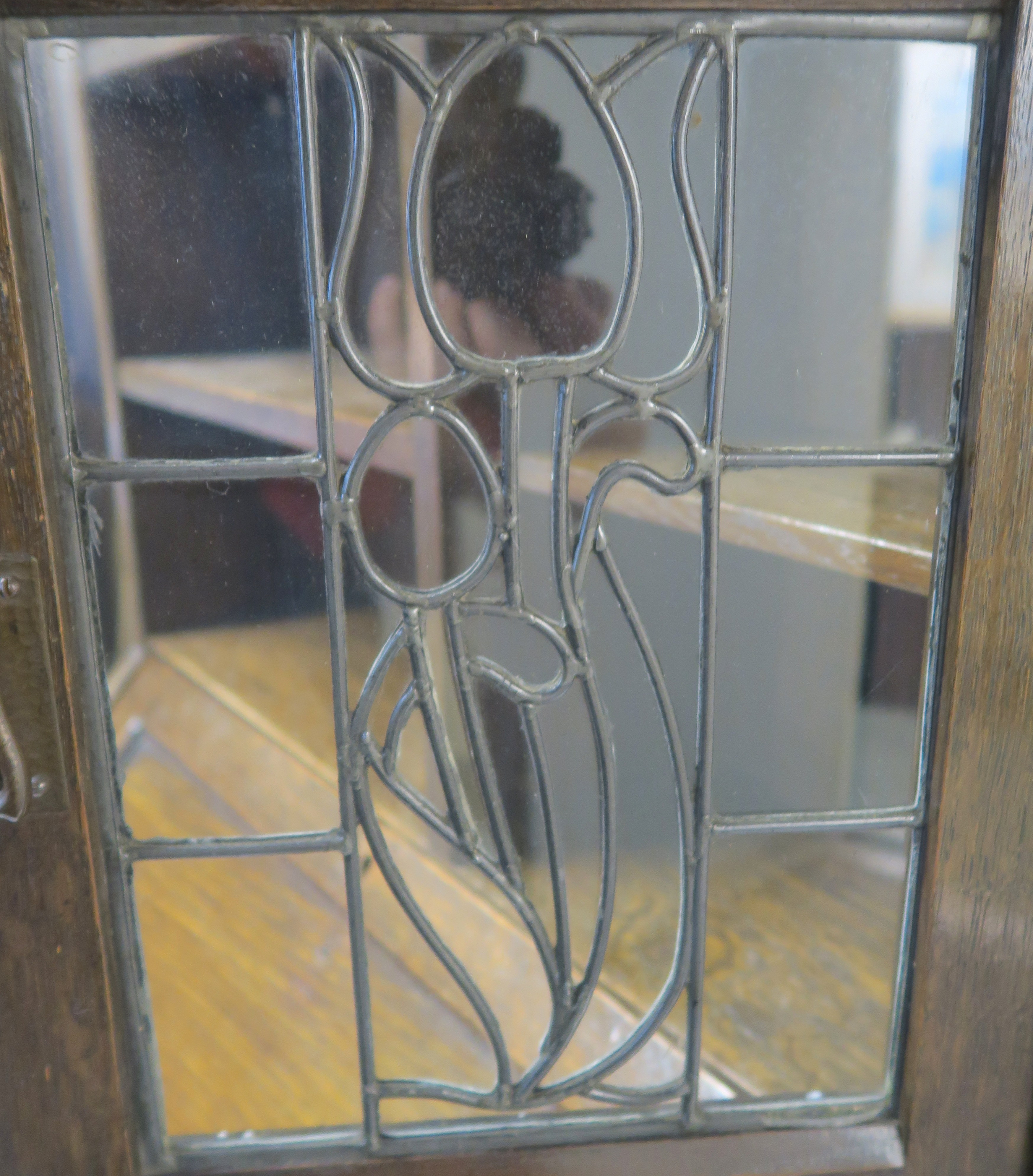 AN ARTS AND CRAFTS OAK WRITING DESK with a stained and leaded glass door and open shelves above a - Image 2 of 8