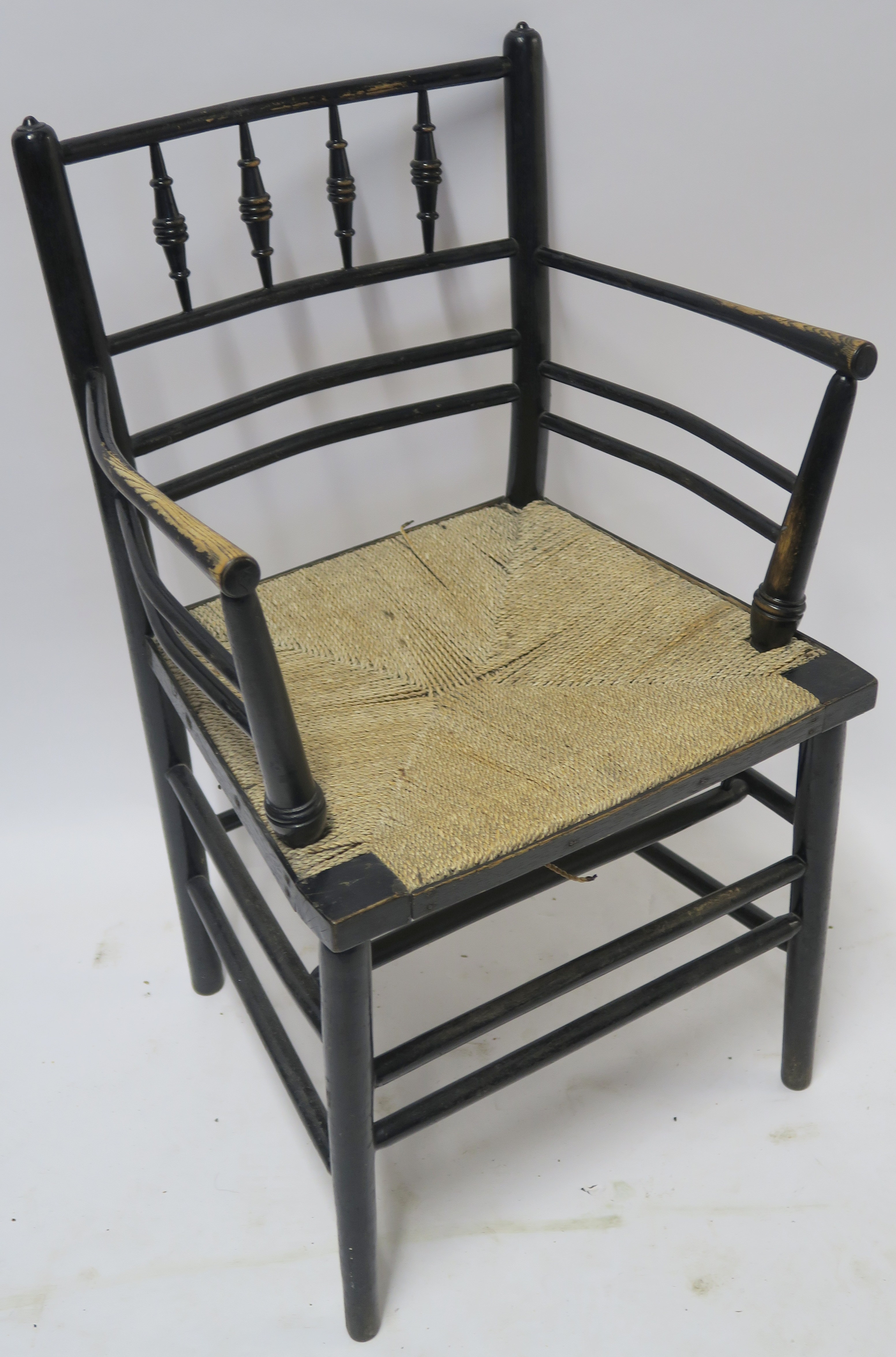 A WILLIAM MORRIS EBONISED SUSSEX CHAIR of standard form with rush seat 85cm high Condition Report: