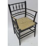 A WILLIAM MORRIS EBONISED SUSSEX CHAIR of standard form with rush seat 85cm high Condition Report: