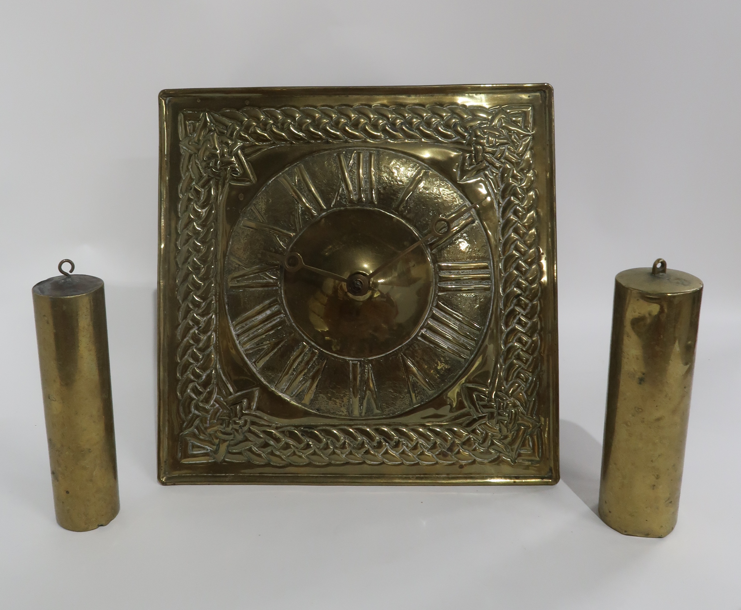 A BRASS ARTS AND CRAFTS WAG AT THE WA CLOCK with Celtic knotwork design, pendulum and weights