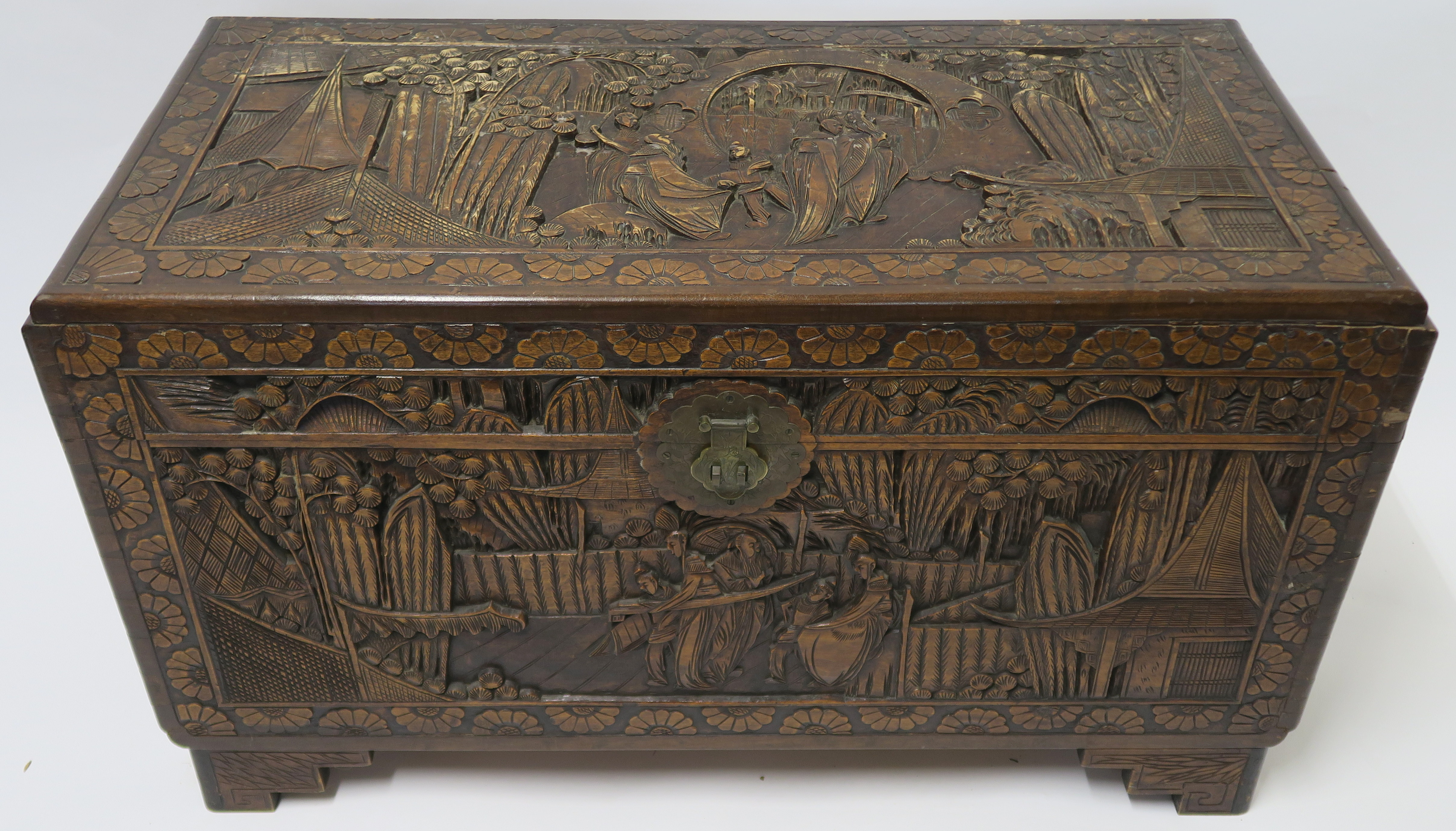 A CHINESE CAMPHOR WOOD CARVED BLANKET CHEST carved allover with figures in gardens, 59cm high, 105cm