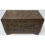 A CHINESE CAMPHOR WOOD CARVED BLANKET CHEST carved allover with figures in gardens, 59cm high, 105cm