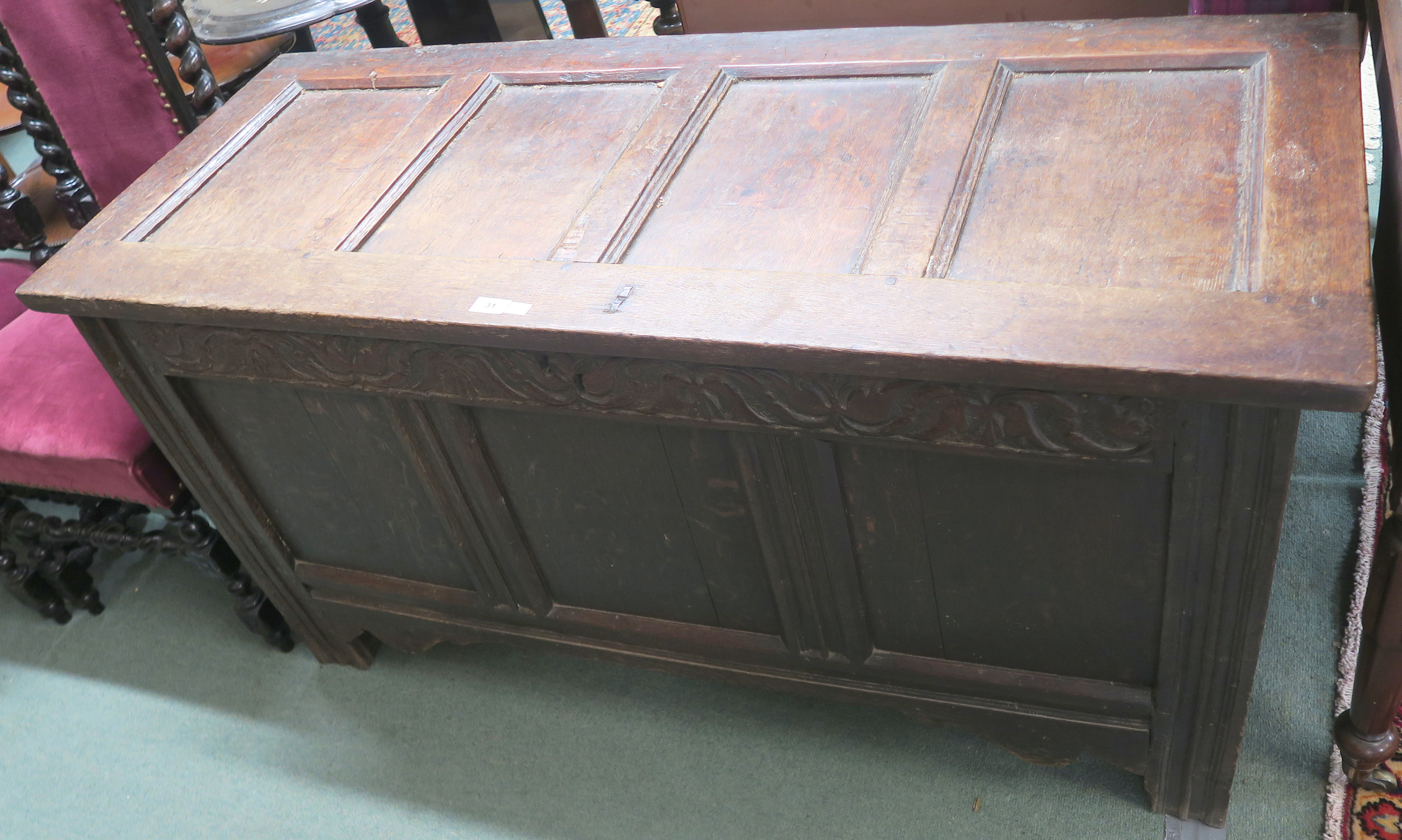 An 18th Century oak panelled coffer with carved frieze, 72cm high x 139cm wide x 56cm deep Condition