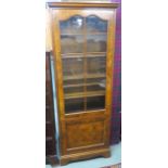 A Mahogany and walnut bookcase with a glazed door over lower door on bracket feet, 164cm high x 66cm