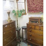 A brass standard lamp with green glass shades, two plant stands, a brass table lamp and Zennox