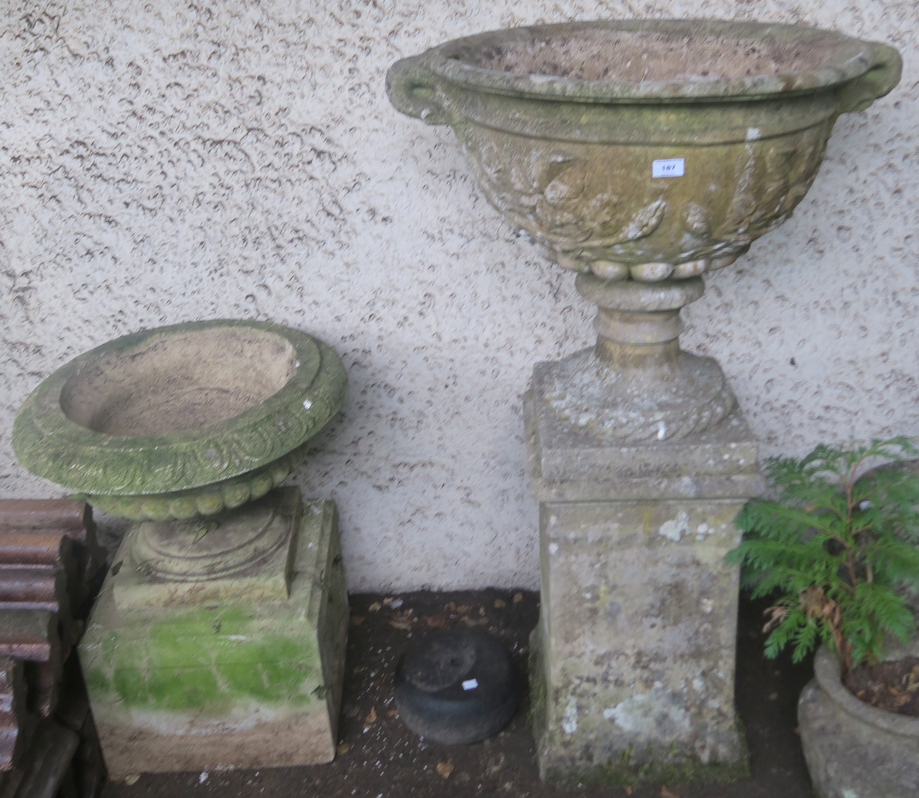 A large reconstituted stone urn on stand, 126cm high and a smaller urn on stand 71cm high (2)