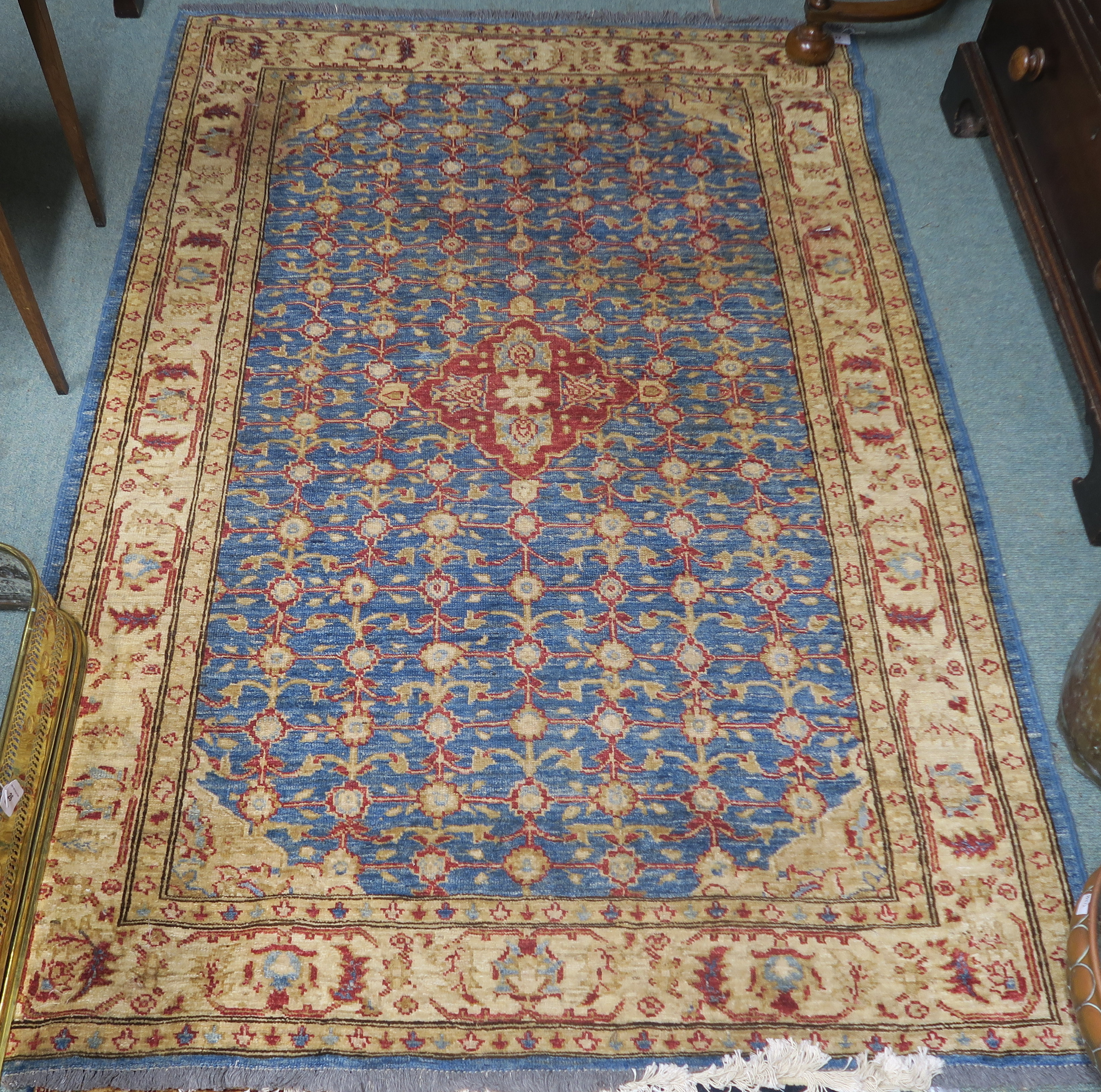 A blue ground eastern rug with central medallion and allover floral design, 187cm x 125cm