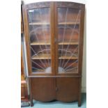 An Art Deco oak bookcase with sunburst leaded glass with carved top over two doors,183cm high x 92cm