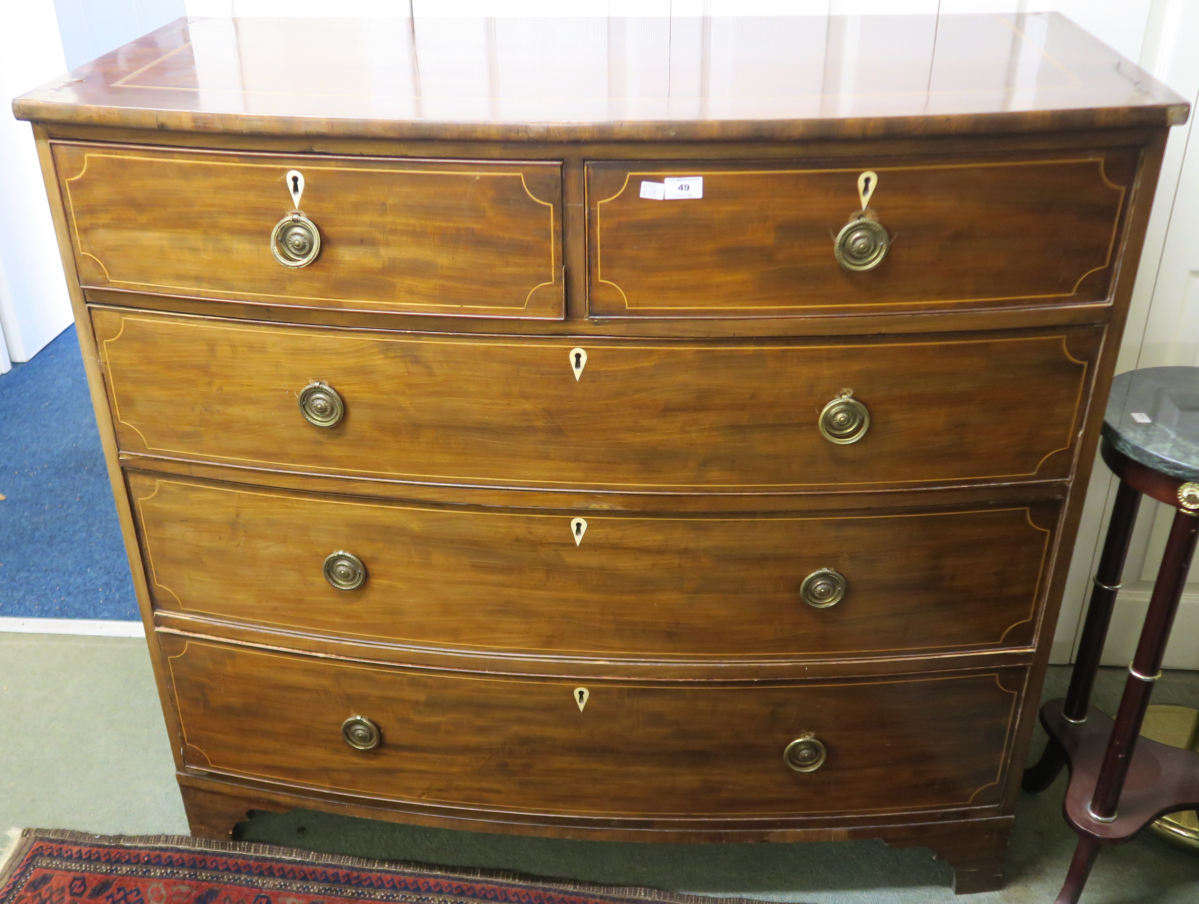 A 19th Century inlaid mahogany two over three bow front chest on bracket feet, 113cm high x 124cm