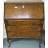 A 20th century mahogany and walnut veneered three drawer writing bureau on cabriole supports,