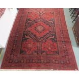 An eastern style red ground rug with stylized animal and geometric design, 370cm long and 270cm wide