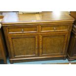 A contemporary walnut veneered sideboard with two drawers above two cabinet doors, 90cm high,