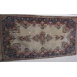 Two beige ground floral pattern rugs with central medallions and blue borders, 220cm long and