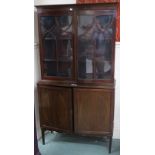 A Victorian glazed two door bookcase on two door cabinet base with tapering supports, 181cm high,