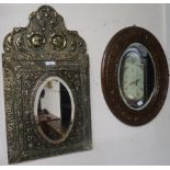 A lot comprising a brass framed cushion mirror with single door, small carved mahogany wall mirror