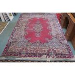 A pink ground floral pattern rug with central medallion and blue spandrels, 307cm long x 220cm