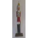 A carved figure of a soldier base bearer a plaque "The Life Guards c. 1914", 134cm high Condition