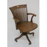 A 20th century oak comb back revolving desk chair, 89cm high Condition Report: Available upon