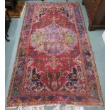 A red ground rug with central medallion and blue borders, 227cm long x 130cm wide Condition