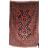 A red ground eastern rug with dual medallions, 160cm long x 103cm wide Condition Report: Available