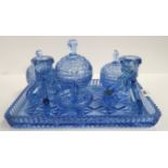 A blue pressed glass dressing table set with tray, candlesticks, ring holder and three lidded pots