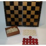 A carved draughts set, fifteen white and sixteen red, lacquered folding chess board, cased