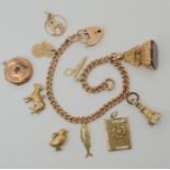 A 9ct rose gold curb link charm bracelet with heart shaped clasp and five 9ct attached charms one