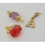 Two 9ct gold glass charms and a 9ct gold 'A' pendant, weight together 6.7gms Condition Report: