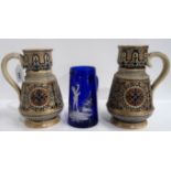 A pair of German stoneware jugs with incised decoration and a Mary Gregory style blue glass jug