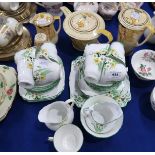 A Narcissus decorated teaset comprising eight cups, twelve saucers, eleven plates, cake plate, two
